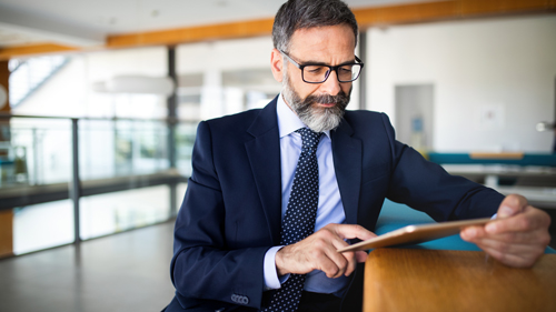 businessman using tablet in modern office setting with focus on technology and productivity