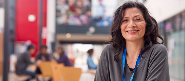 smiling woman in casual attire in a cafe setting with people in the background engaged in conversation and enjoying their time together promoting community connection and socialization